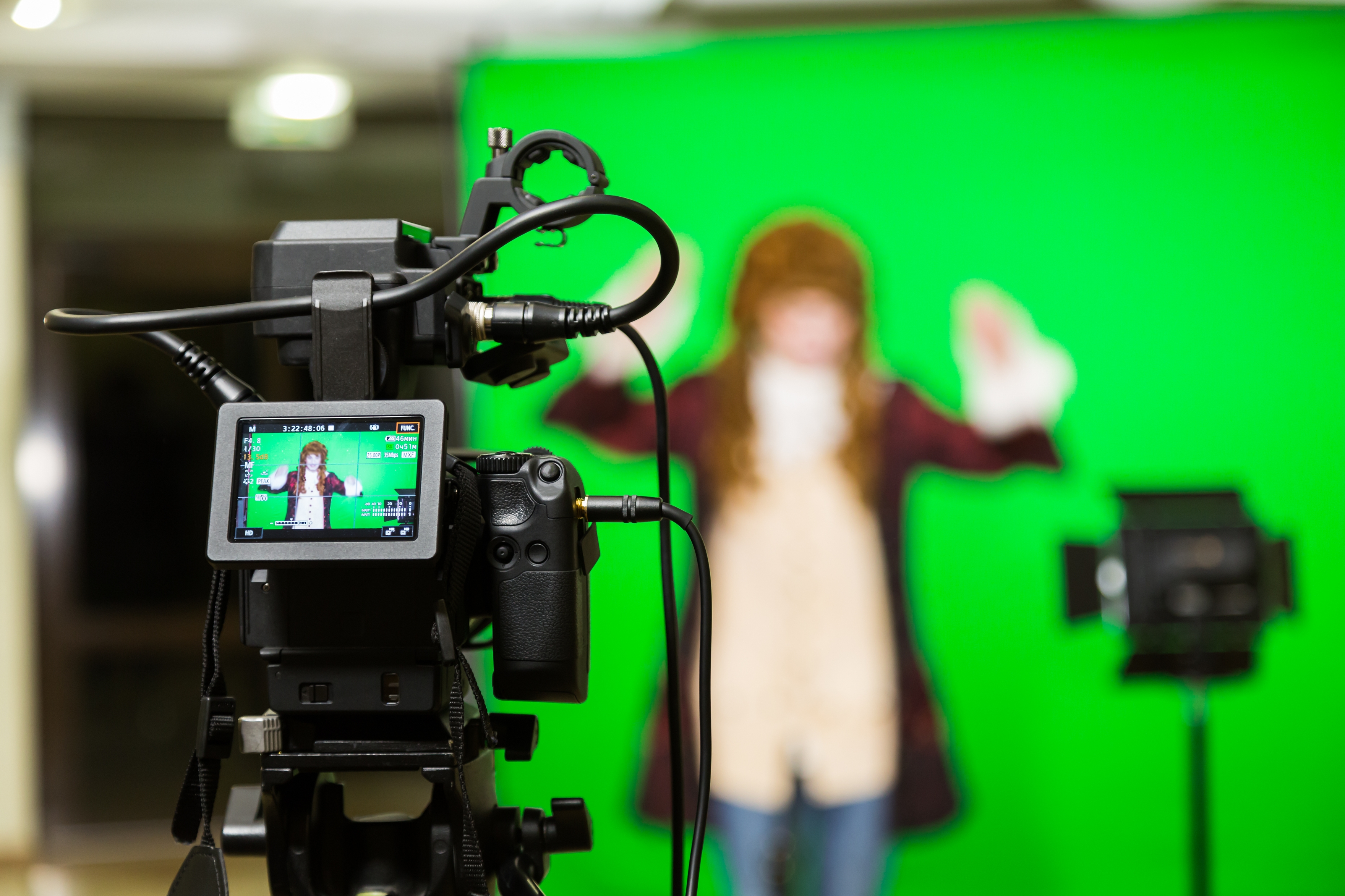 A green screen with a person in the background
