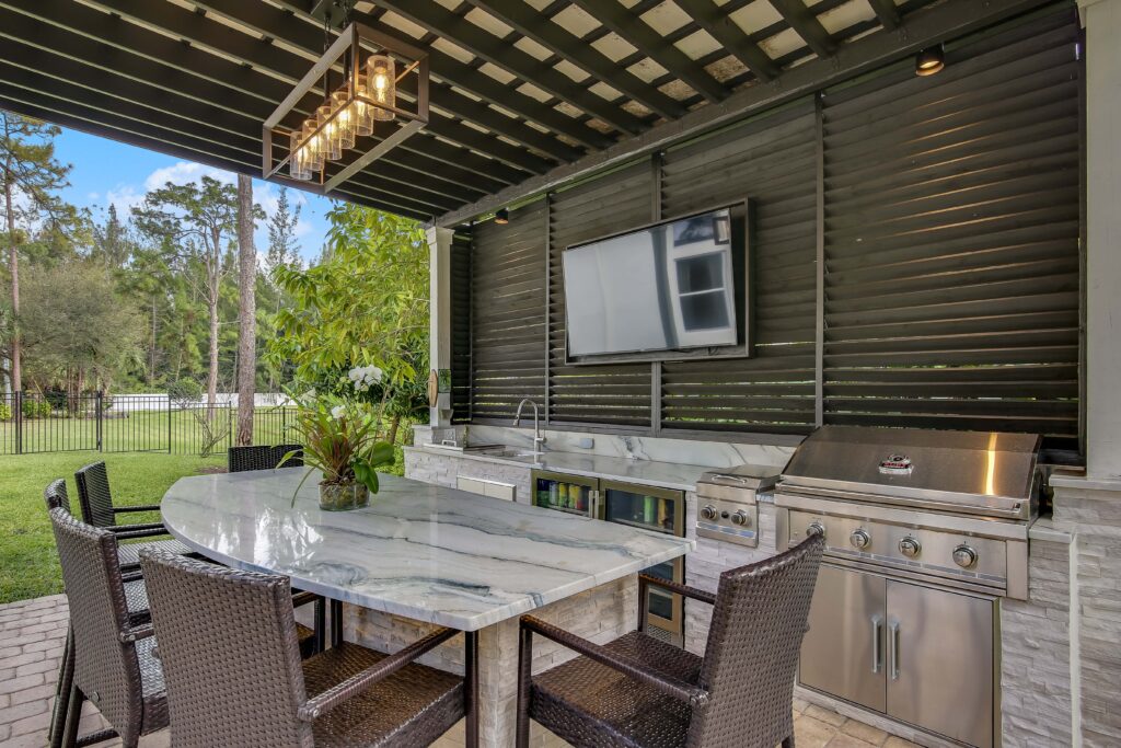 A table and chairs in the middle of an outdoor kitchen.