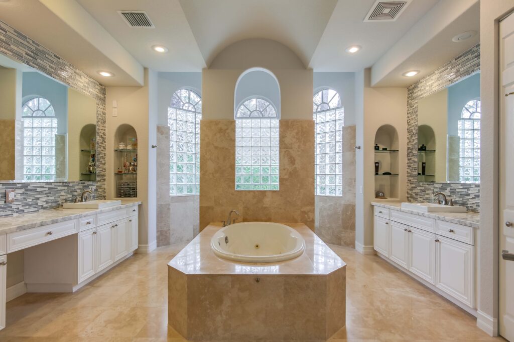 A large bathroom with two sinks and a tub.